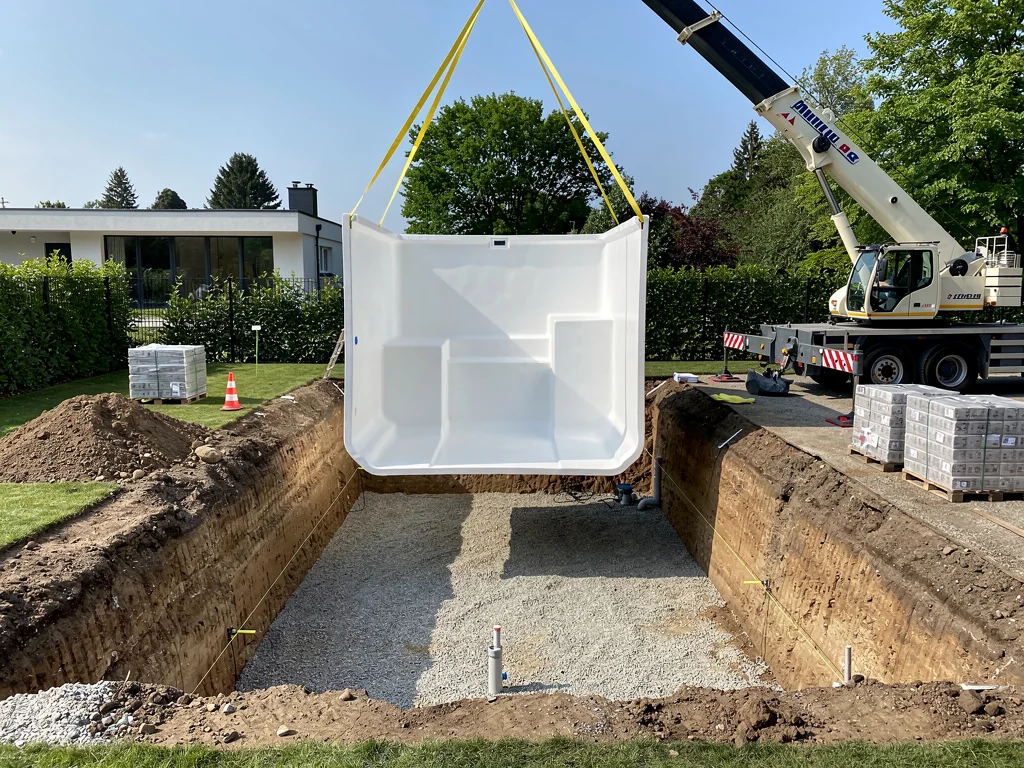 Coque de piscine descendue à la grue au-dessus de sa fouille